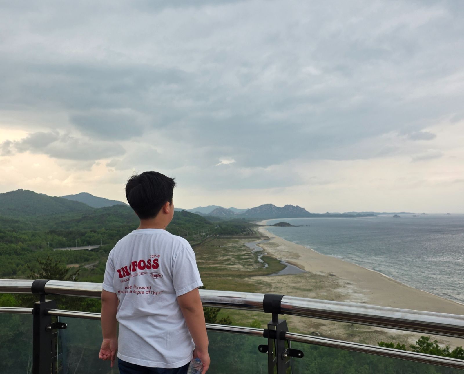 전망대 난간에서 북녘 땅과 바다를 바라보는 학생의 뒷모습