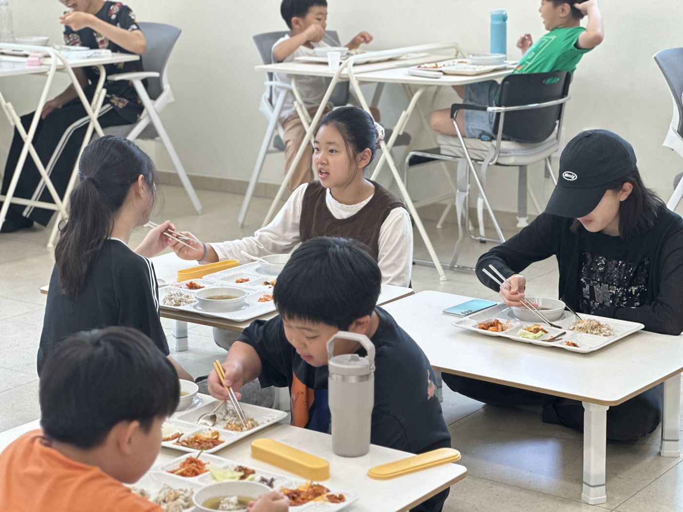 교실에서 여러 학생이 함께 점심을 먹는 모습