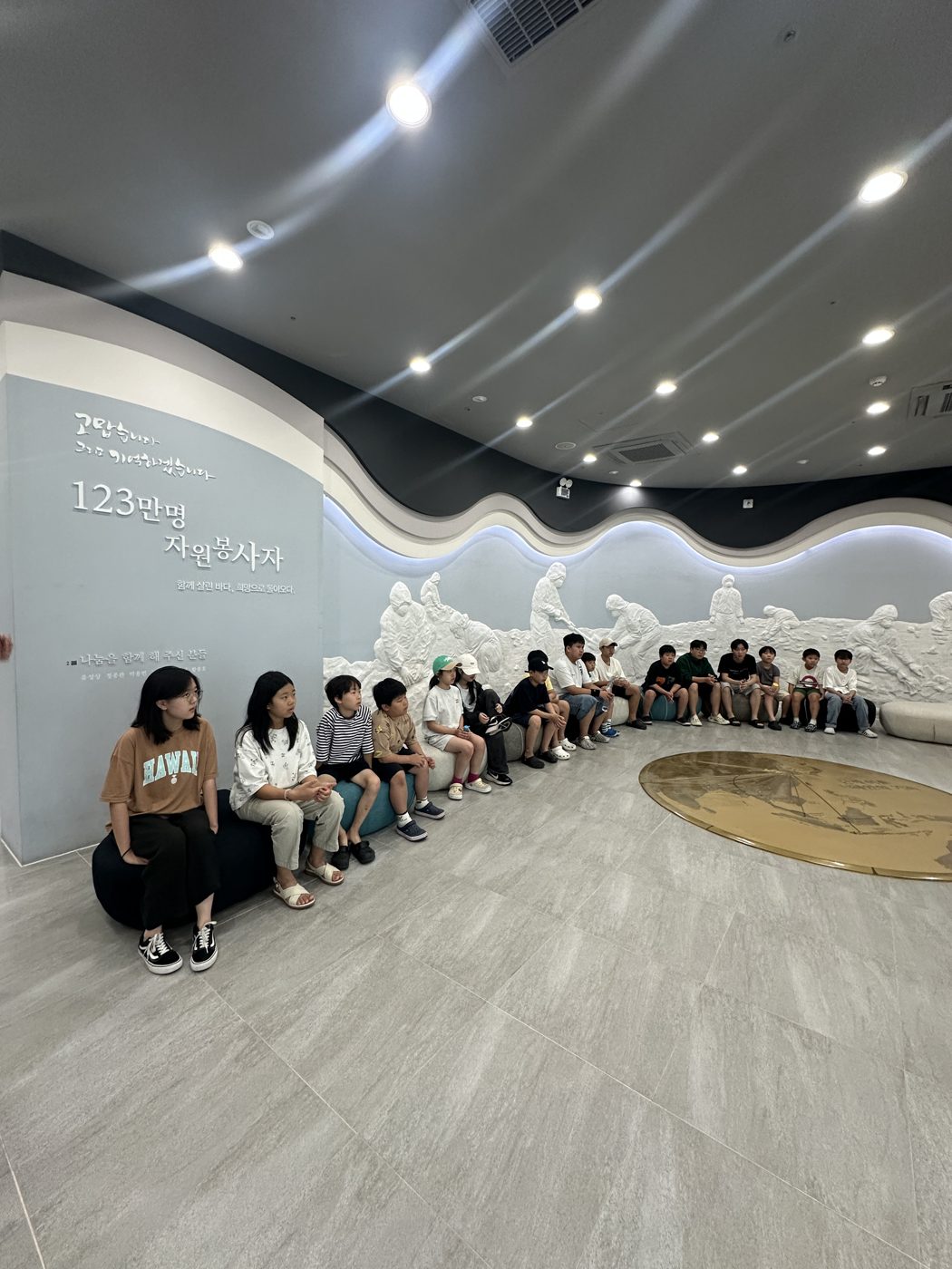 전시관 안에 나란히 앉은 학생들