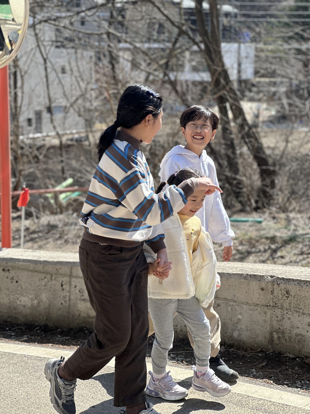언니와 동생들이 함께 웃으며 걷는 모습