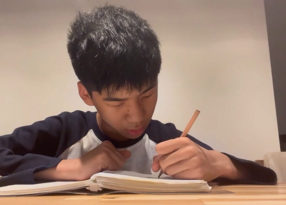 책상에서 플래너를 쓰는 학생